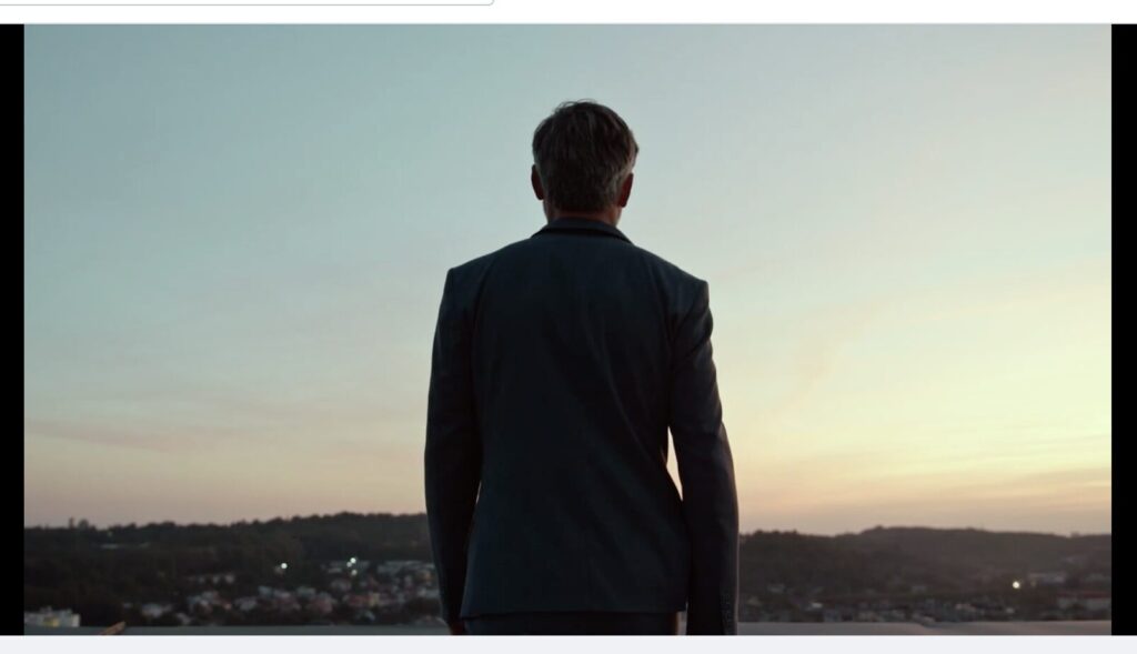 Homem Executivo no topo de um prédio fazendo alusão à solitude de um empresário ou CEO na tomada de decisões estratégicas de uma empresa.